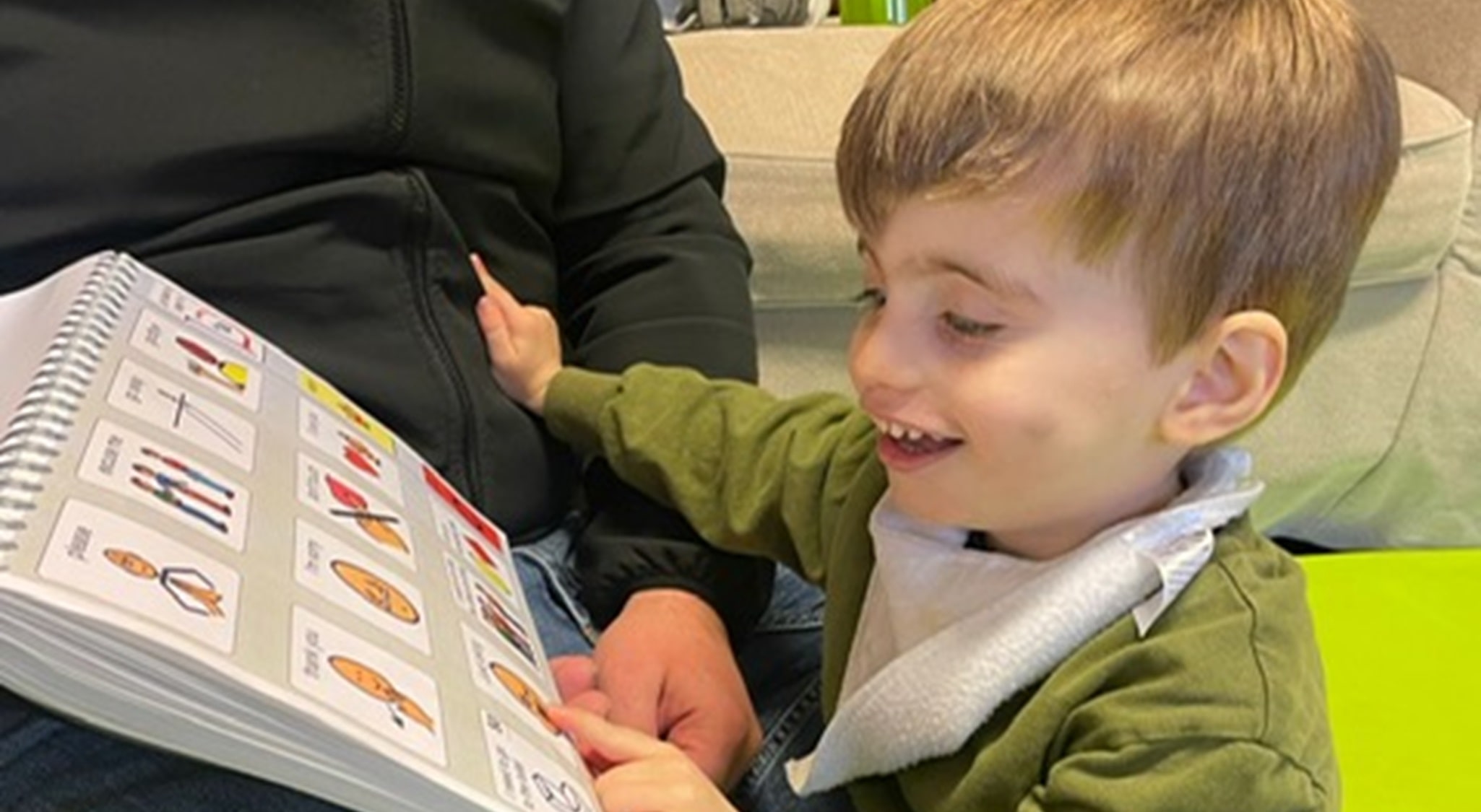 A young boy using his PODD book.