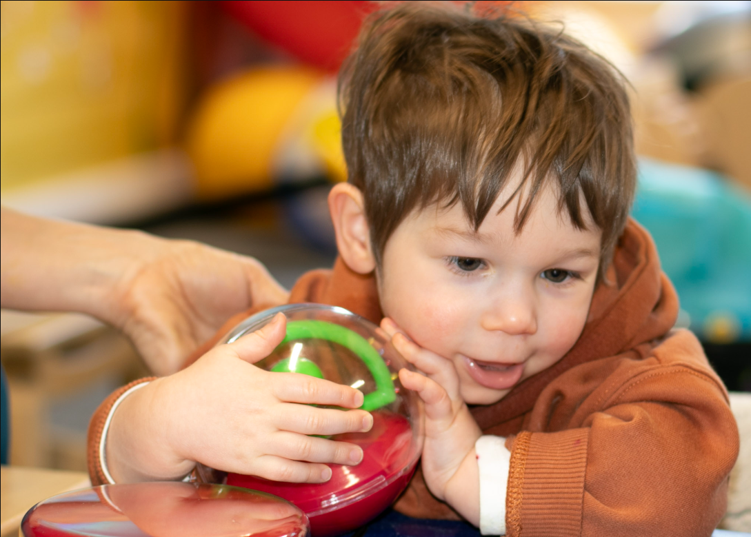 A young boy with Galloway-Mowat syndrome in his conductive education session.