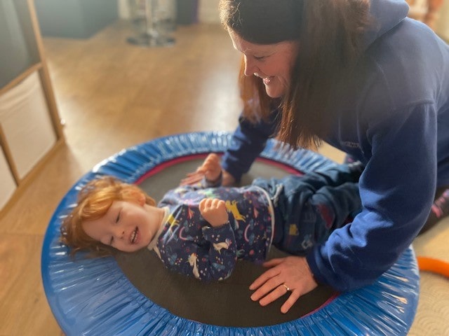 Jothi bouncing on the trampoline with Carol, one of DVLCC's outreach workers.