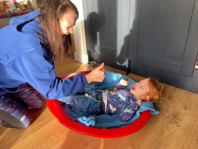 A young boy with cerebral palsy receiving outreach home-play.