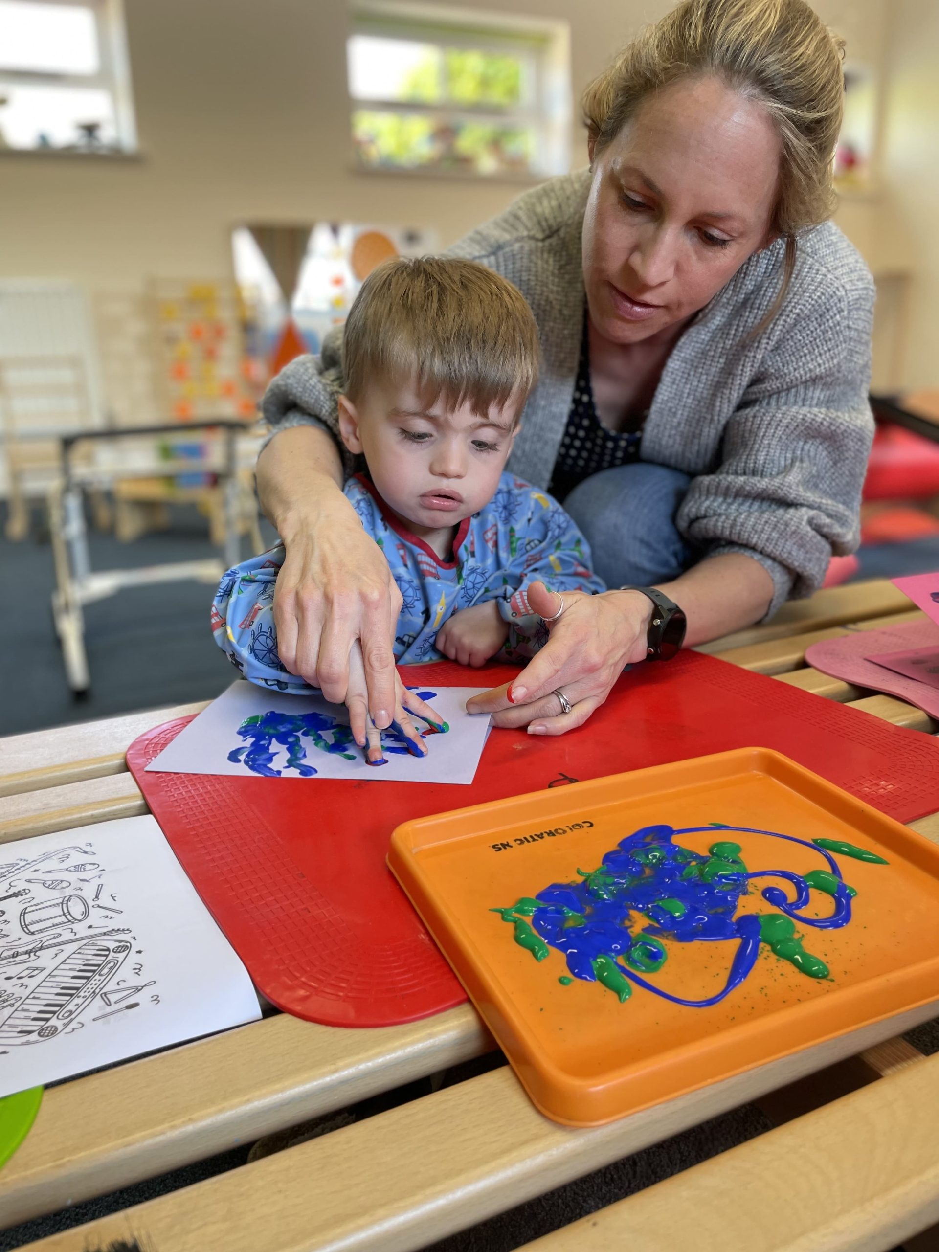 Finlay painting in a conductive education session.