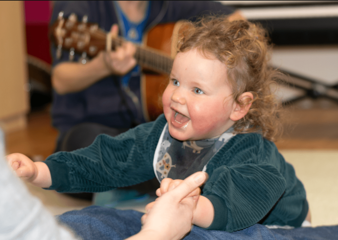 A young girl with Angelman's Syndrome enjoying her music therapy session.