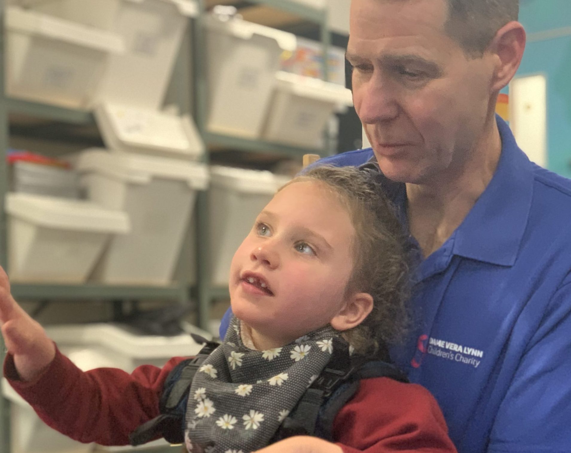 A young girl being supported by a physiotherapist.